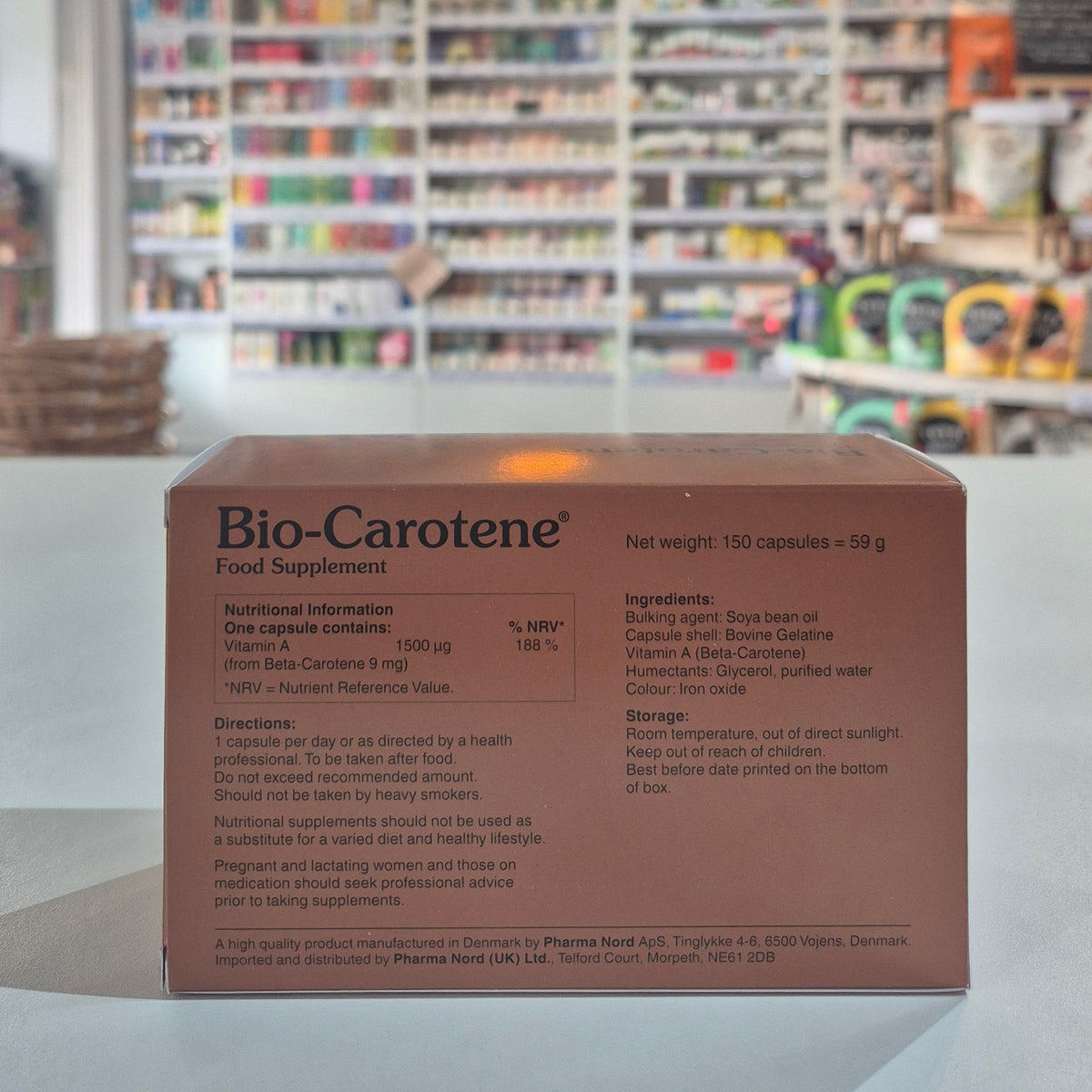 Box of Bio-Carotene food supplement with blurred store shelves in the background