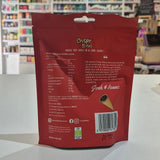 A person holds a red bag of Crispr Bites Dark Chocolate Filled Waffle Cones in a brightly lit shop interior with the ingredients showing. 