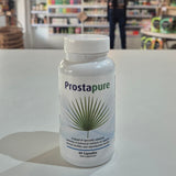 Prostapure supplement bottle on a white surface with a blurred store background