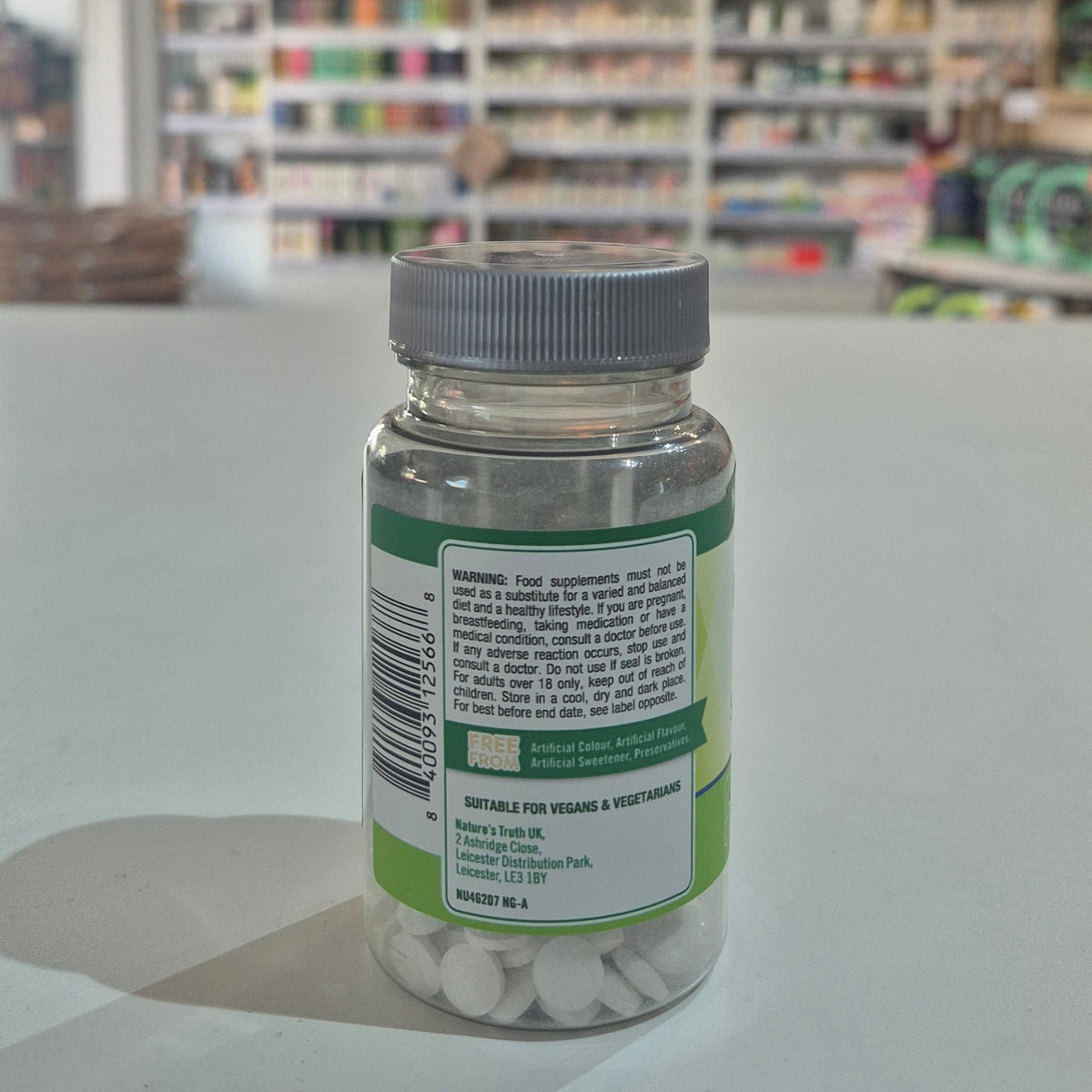 Bottle of supplements with a label on a counter in a store setting