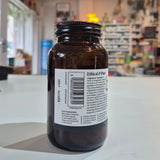 Bottle of Viridian Magnesium Taurate on a counter in a store setting. Brown glass bottle with a label on a white surface, blurred store interior in the background