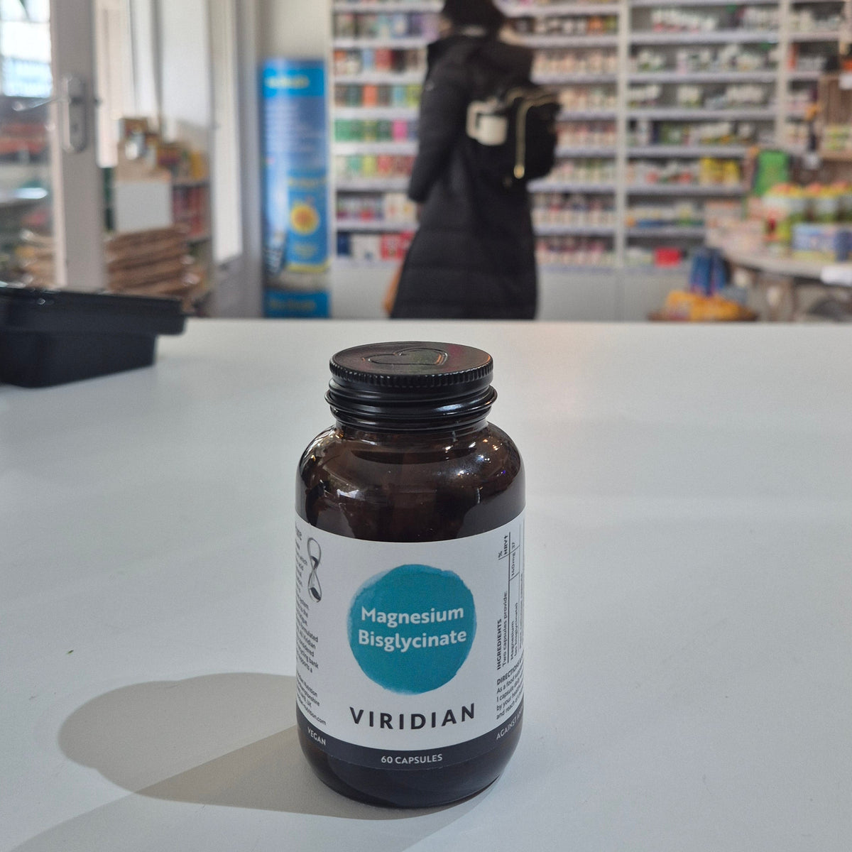 Bottle of Viridian supplements on a white surface with a blurred background