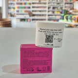 Pink deodorant refill box labeled 'fussy' on a gray surface with a blurred store background.