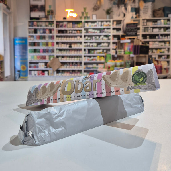 Unopened obar vegan chocolate with packaging against a wall with shelves and decor