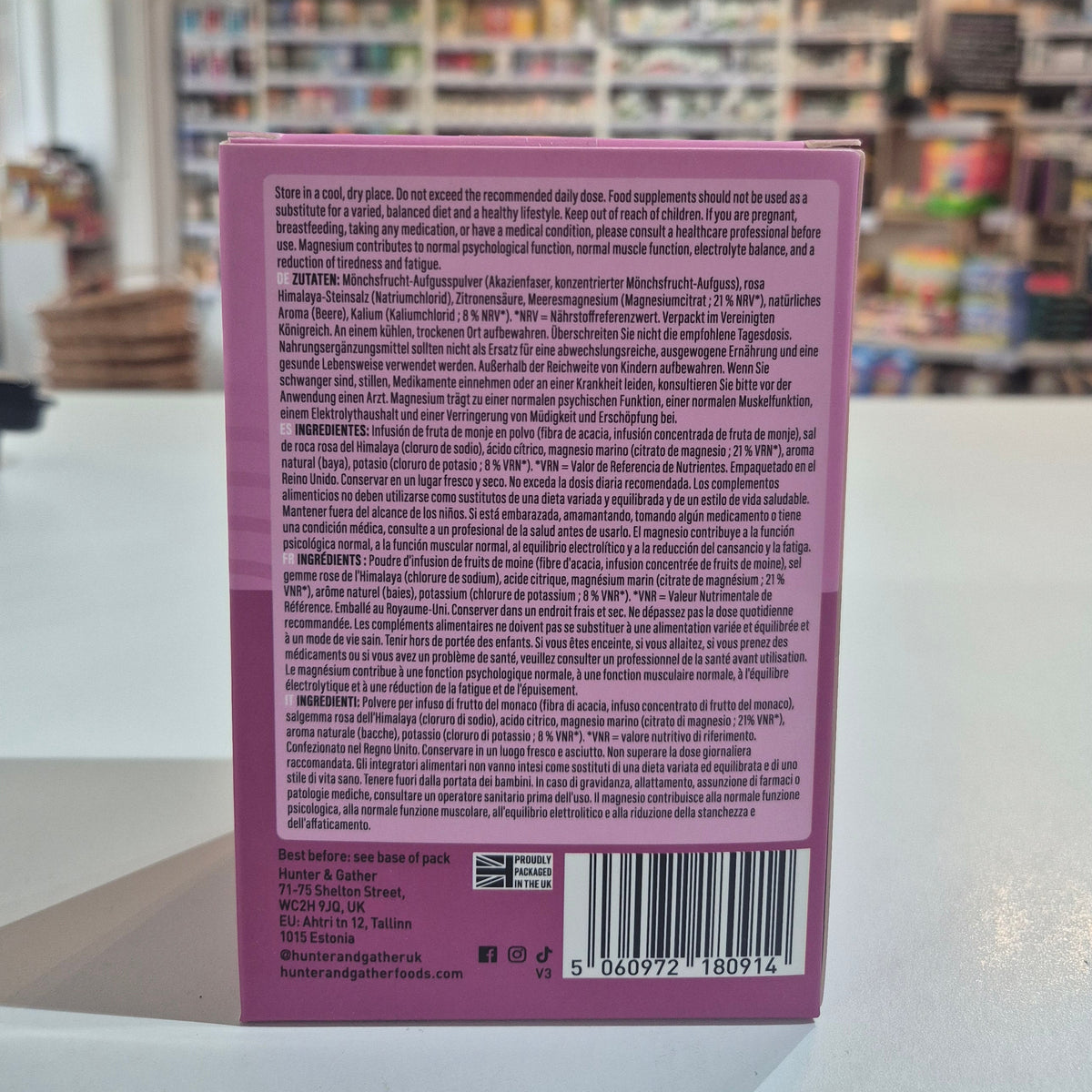 Purple Hunter & Gather supplement package with 'Restore' and 'Mixed Berry' text on a blurred indoor background. 