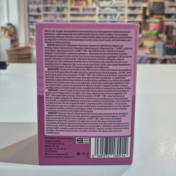 Purple Hunter & Gather supplement package with 'Restore' and 'Mixed Berry' text on a blurred indoor background. 