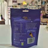 A purple stand-up pouch of Crispr Bites Milk Chocolate Filled Waffle Cones on a white countertop in a blurred retail shop setting with the ingredients showing.