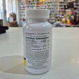 NaturesPlus Cal/Mag/Vit D3 supplement bottle on a table with a blurred store background