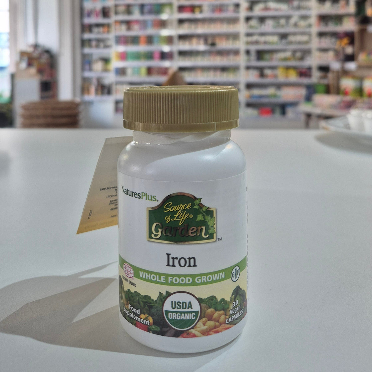 A bottle of Nature's Plus Source of Life Garden Iron, certified organic iron whole food grown, with the USDA organic seal displayed in a store setting
