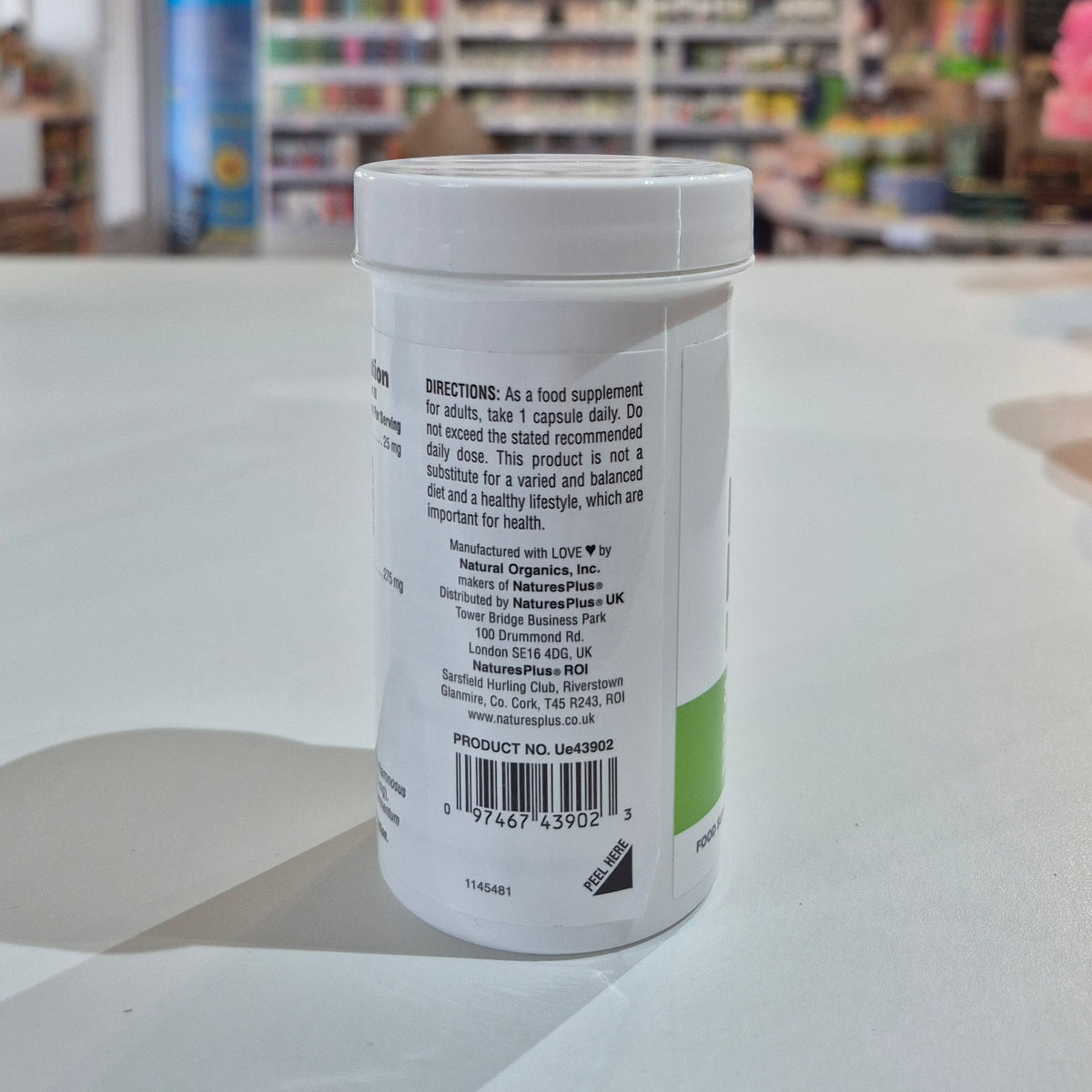 Container with a label on a white surface, blurred background