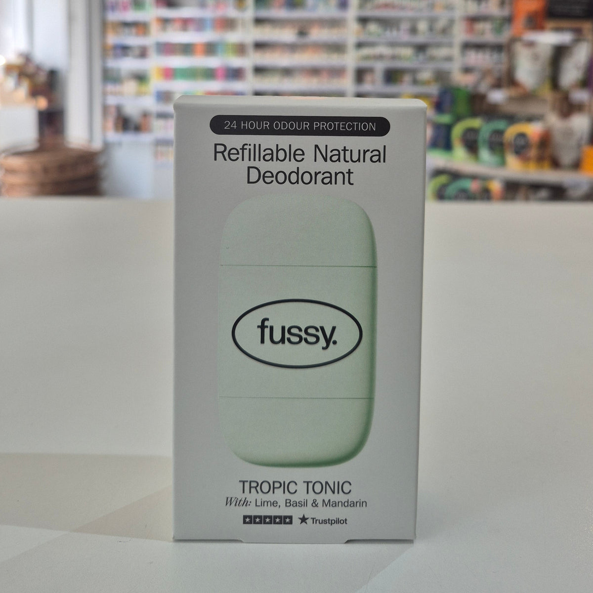 Box of fussy refillable natural deodorant on a white surface with a blurred background