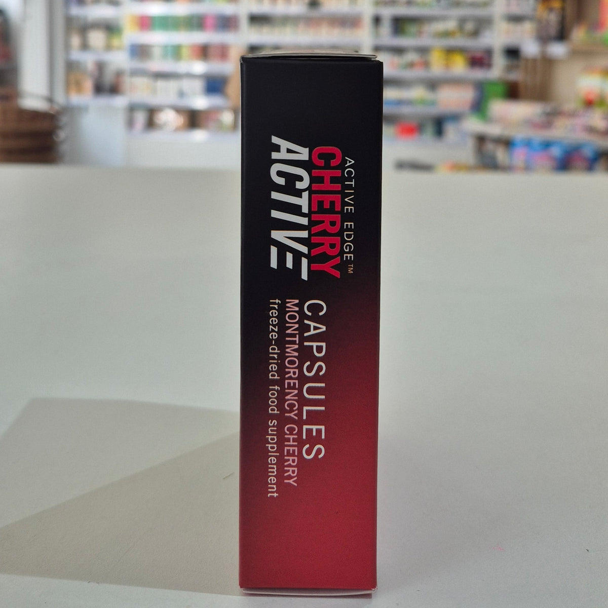 Box of Cherry Active Capsules on a surface with a blurred background