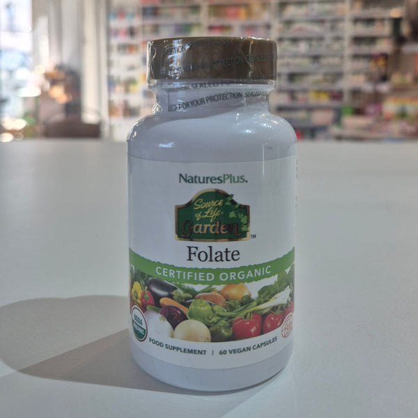 NaturesPlus Folate supplement bottle on a counter with a blurred store background
