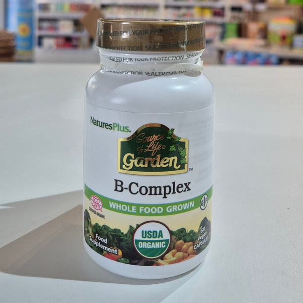 Nature's Plus B-Complex supplement bottle on a white surface with blurred store background