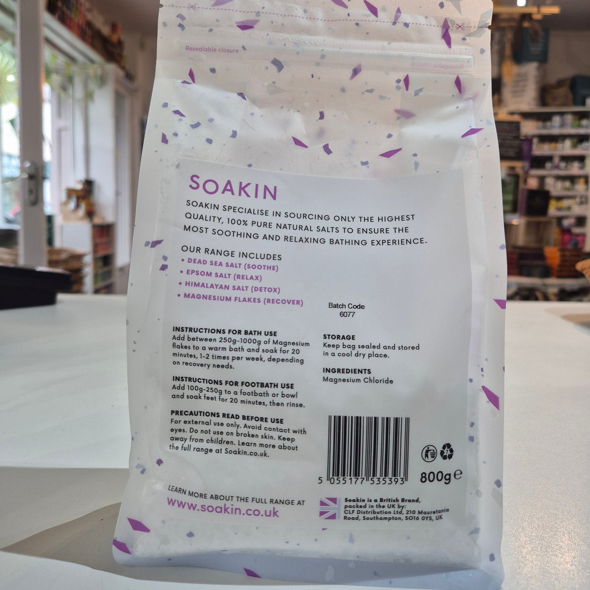 Product packaging with text and a barcode on a stand in a store setting