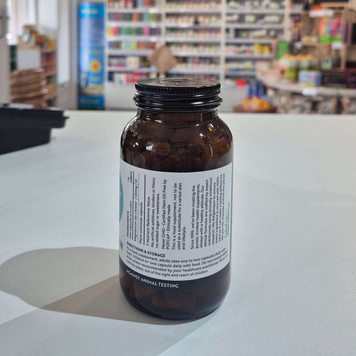 Brown glass bottle with a label on a white surface in a store setting