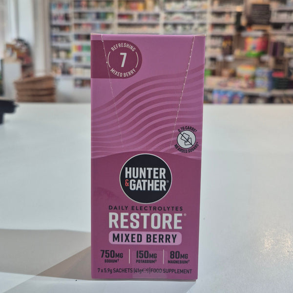 Purple box of Hunter & Gather Restore Mixed Berry electrolytes with a blurred store interior in the background