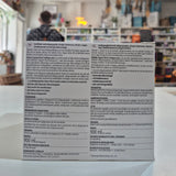 Product packaging with text and a blurred indoor background