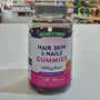 Nature's Truth Hair, Skin & Nails Gummies bottle on a white surface with a blurred store background.