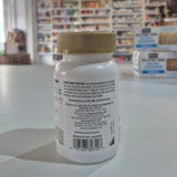 Bottle with a gold cap on a white surface, blurred background