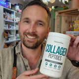 Man holding a container of NaturesPlus Collagen Peptides in a store setting.