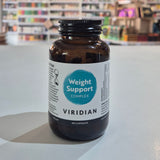 Brown supplement bottle labeled 'Weight Support Complex' by Viridian on a white surface with a blurred store background.