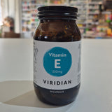 Jar of Viridian Vitamin E capsules on a white surface with a blurred store background