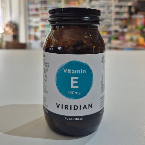 Jar of Viridian Vitamin E capsules on a white surface with a blurred store background