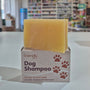 Bar of soap and box labeled 'Dog Shampoo' in a store setting