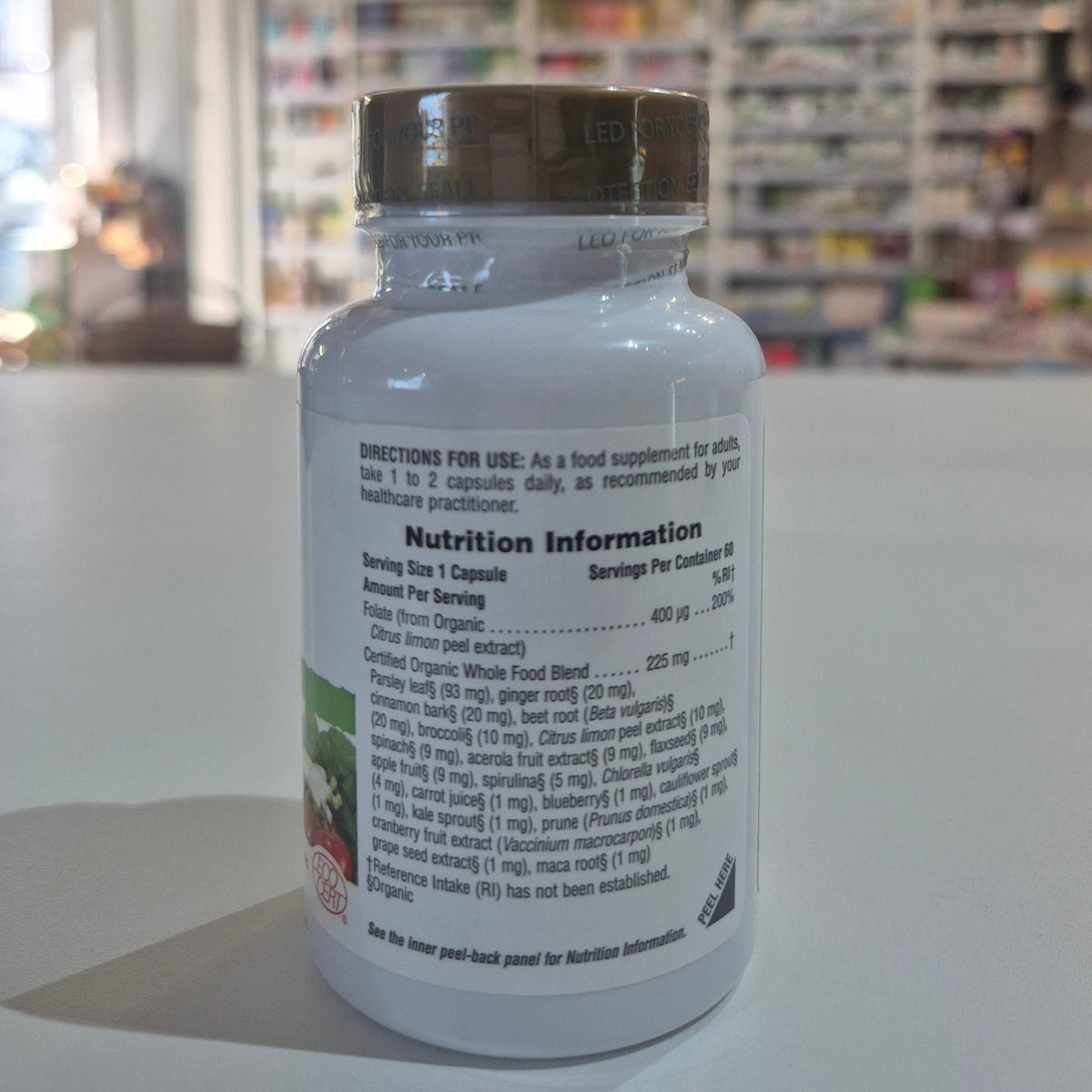 Supplement bottle with nutrition information label on a blurred store shelf background