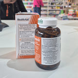 Health Aid supplement bottle and packaging on a counter with a blurred store background