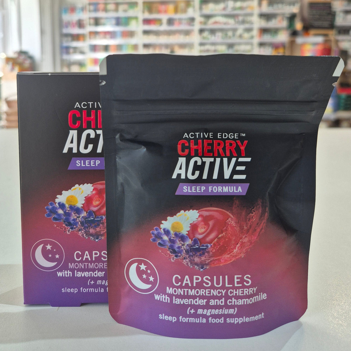Two packages of 'Active Cherry Active' capsules on a white surface with a blurred background.