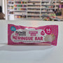 A pink and white packaged snack bar labeled 'Fruity Snacks Meringue Bar' hanging against a white wall, with a blurred store interior visible in the background.
