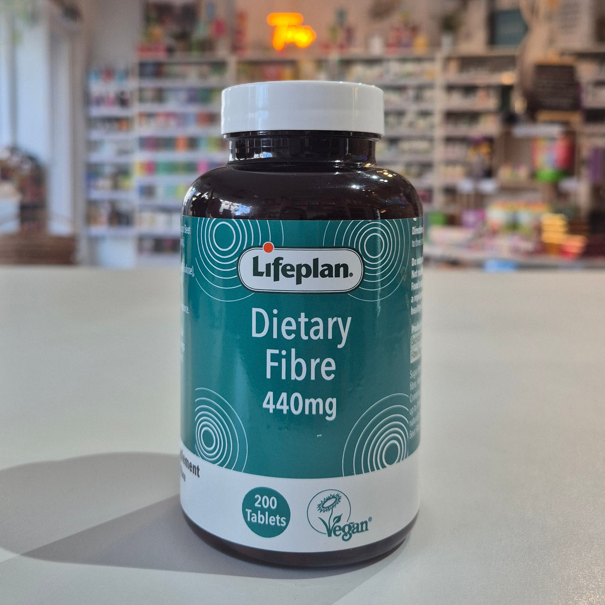 Lifeplan Dietary Fibre 440mg supplement bottle on a counter with a store background