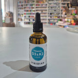 Bottle of Viridian Vitamin D3 & K2 Liquid on a table with a blurred store background