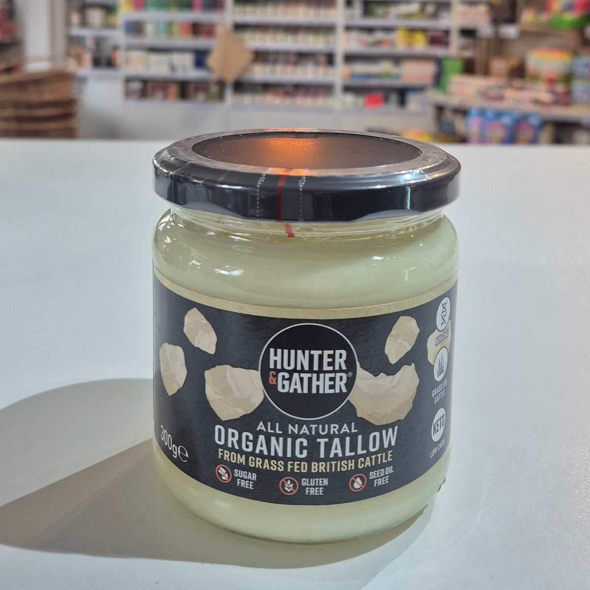 Jar of organic Hunter & Gather all-natural Organic Tallow on a white surface with a blurred background