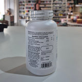 Collagen peptides supplement bottle on a table with a store interior in the background. Supplement bottle with label on a table in a store setting