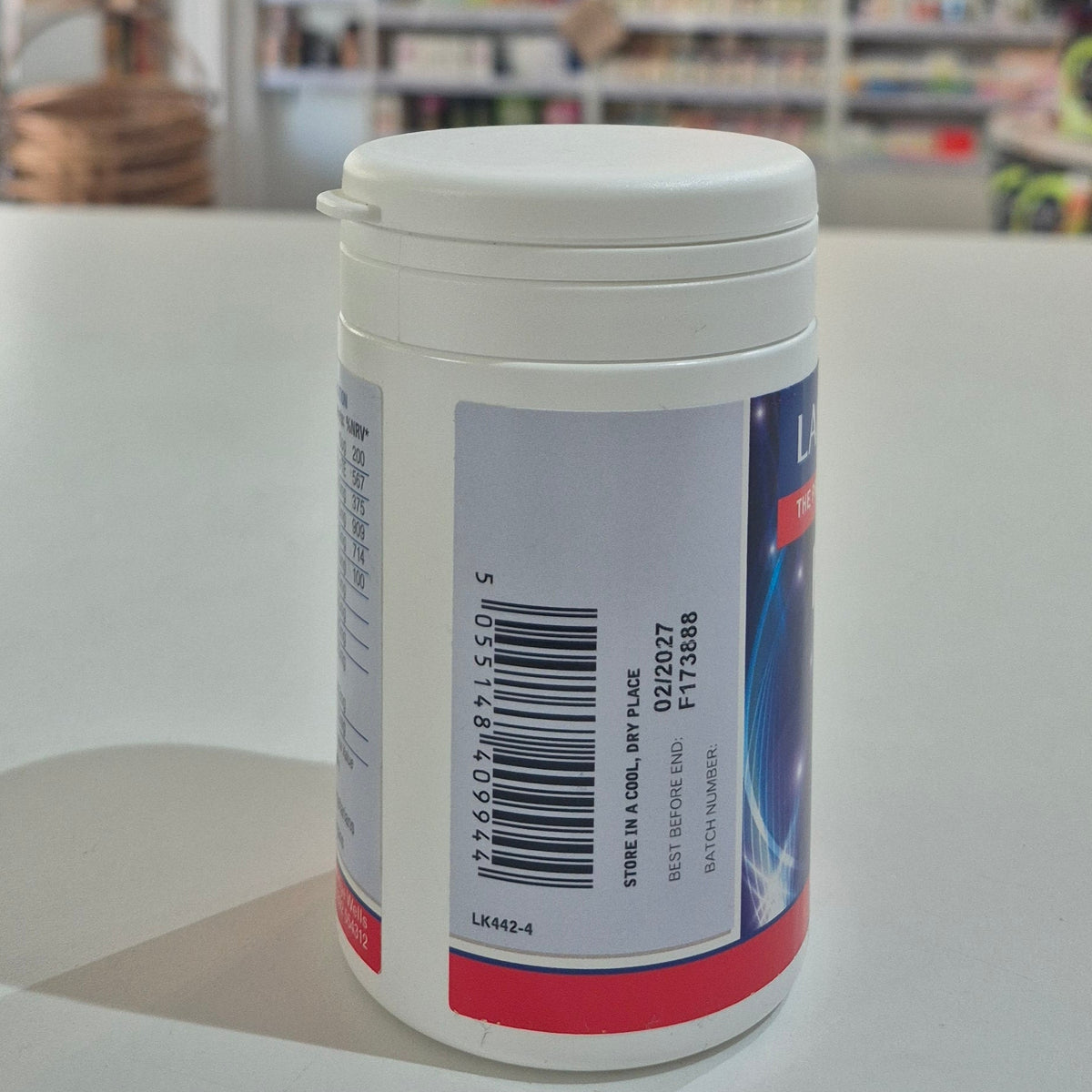 White container with a label featuring a barcode on a white surface.