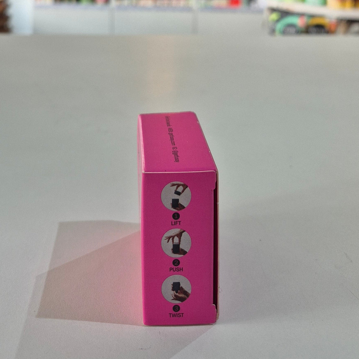 Pink box with instructions on a gray surface