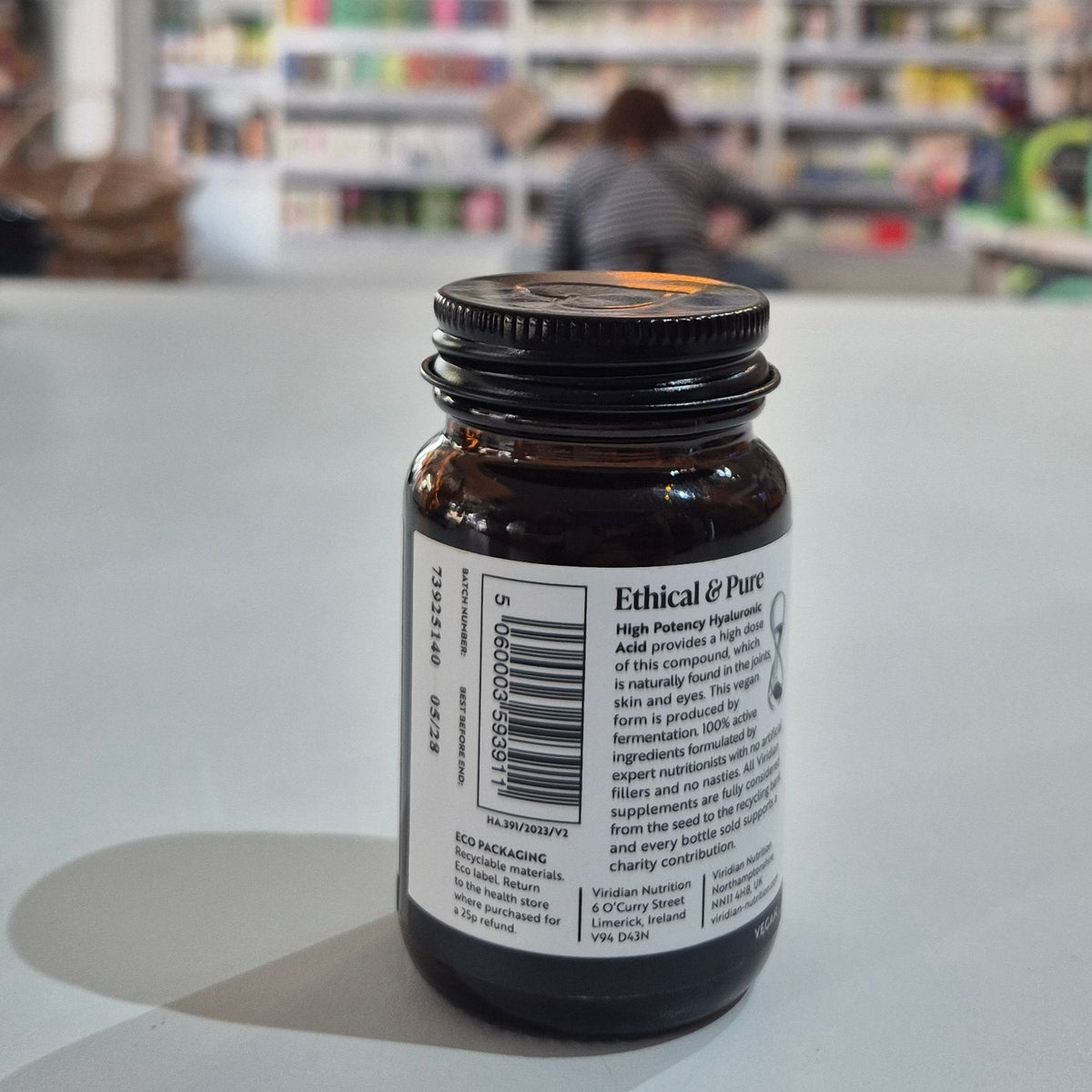 Bottle with a label on a white surface, blurred background