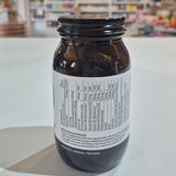 Jar of Viridian High Twelve B12 B Complex supplement on a white surface with a blurred store background.. Brown bottle with label on a white surface, blurred background