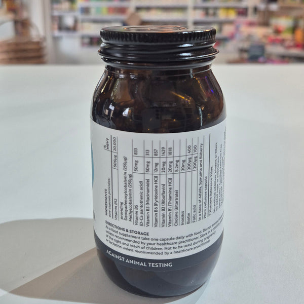 Jar of Viridian High Twelve B12 B Complex supplement on a white surface with a blurred store background.. Brown bottle with label on a white surface, blurred background