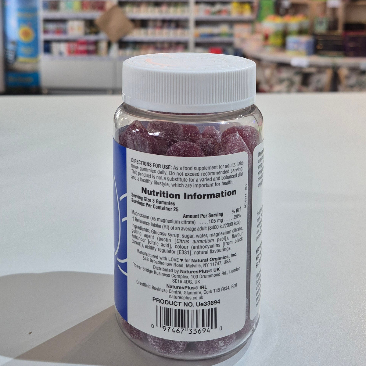 Bottle of vitamins on a counter with a blurred store interior in the background
