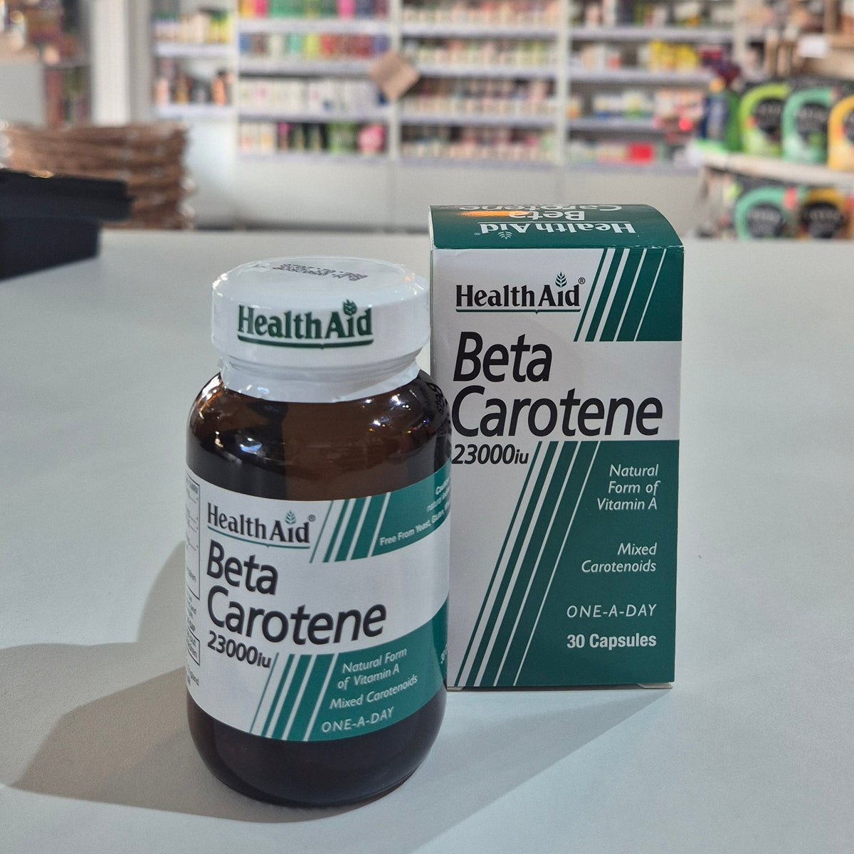 Health Aid Beta Carotene supplement bottle and packaging on a table.