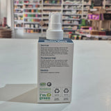 Product packaging with a spray bottle on a surface, blurred shelves in the background