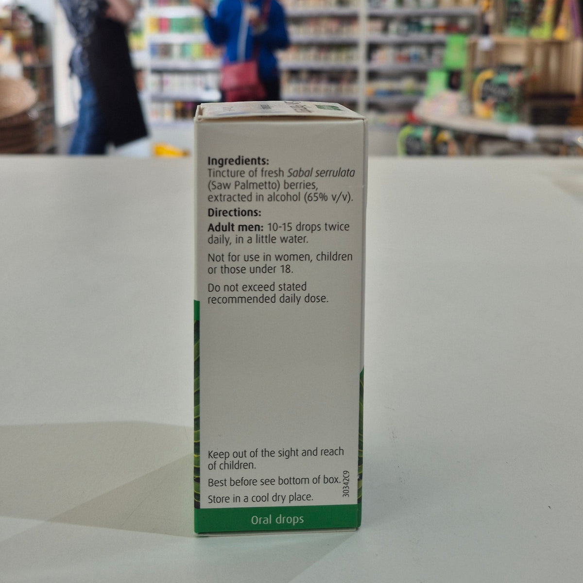 Box of oral drops with ingredients and directions on a counter in a store.