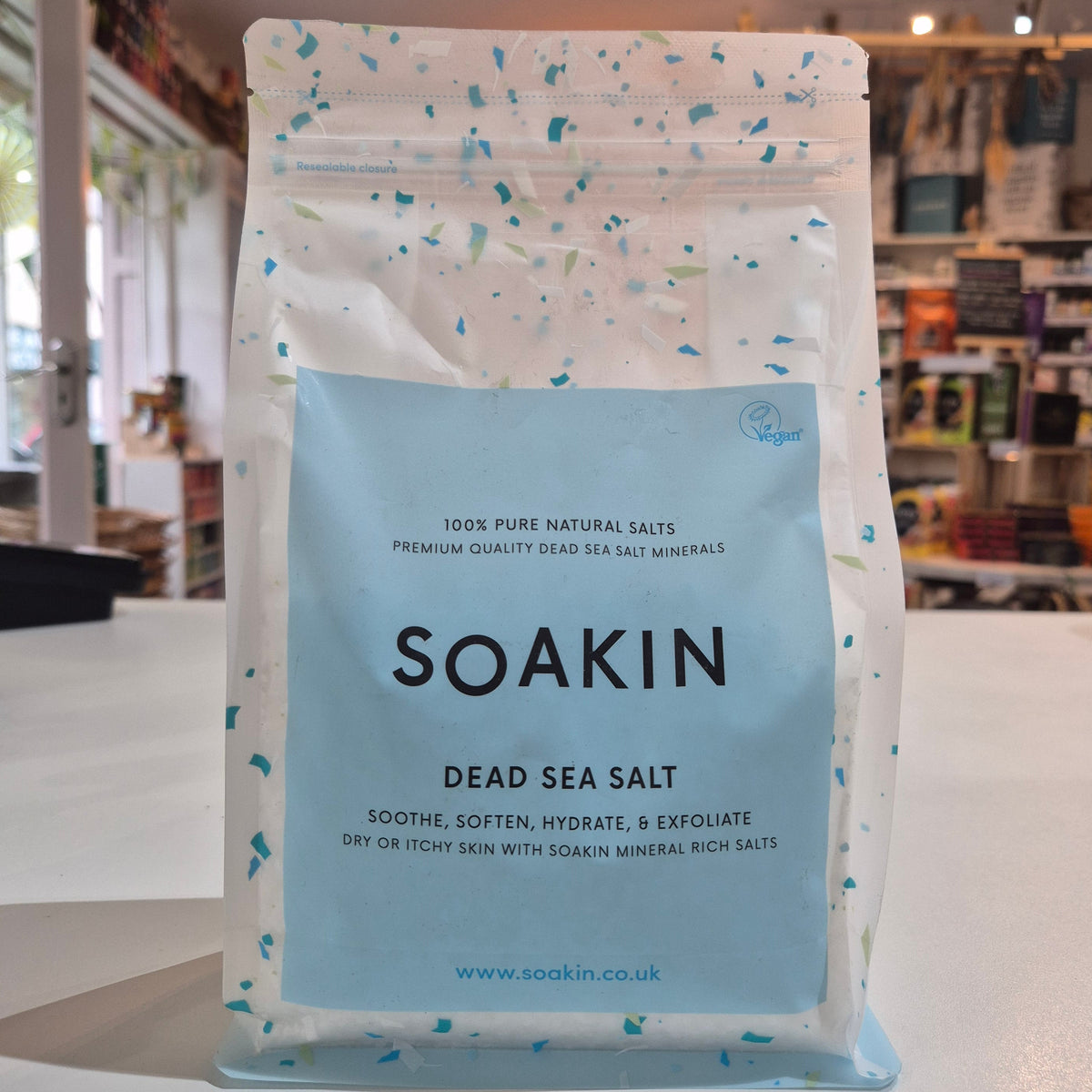 Bag of Soakin Dead Sea Salt with a store interior in the background