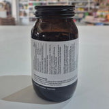 Brown supplement bottle labeled 'Extra C 550mg' by Viridian on a white surface with a blurred store background.