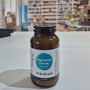 Bottle of Viridian Magnesium Citrate Powder on a white surface with a blurred store background.