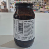 Brown supplement bottle labeled 'Extra C 550mg' by Viridian on a white surface with a blurred store background.